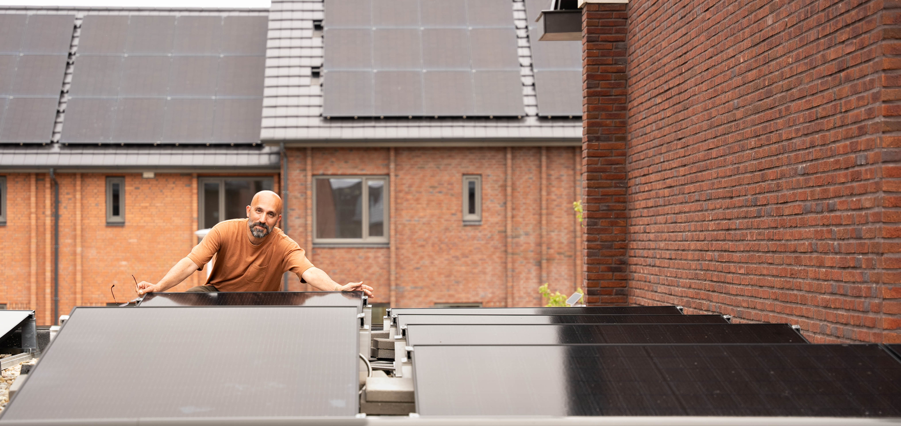 Een man op zijn dak tussen zijn PVT panelen van HR energy